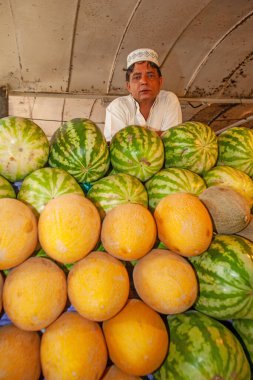 DUBAI, UAE - OCTOBER 12, 2007: Portrait of an unidentified man selling melons at the Fish Souk in Dubai.