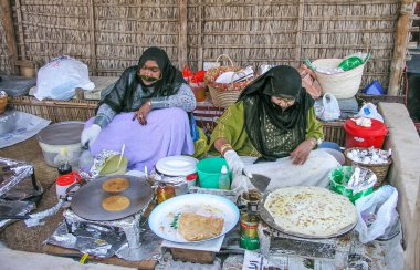 DUBAI, BAE - 11 Ocak 2017: Birleşik Arap Emirlikleri 'ndeki Dubai Miras Köyü' nde krep pişiren kimliği belirsiz iki Arap kadın.