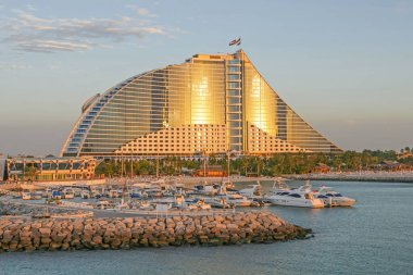 DUBAI, BAE - 28 Nisan 2005: Dubai, Birleşik Arap Emirlikleri 'ndeki Jumeirah Beach Hotel' in küçük tekne limanı ve ana binasında altın saat.