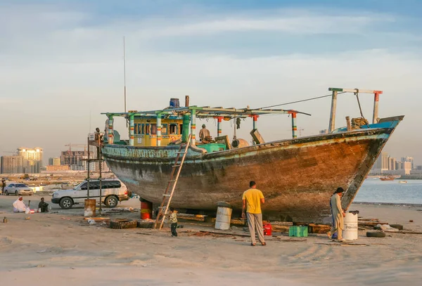 ŞARJAH, BAE - 13 Aralık 2004: İşçiler, Birleşik Arap Emirlikleri 'nin Şeriat kentindeki Al Khan' da ahşap bir çadırı yeniliyorlar. Al Khan Körfezi 'nde yer alan bölge bir zamanlar terk edilmiş ve parçalanmış geleneksel mercan evleri koleksiyonuna ev sahipliği yapıyordu..