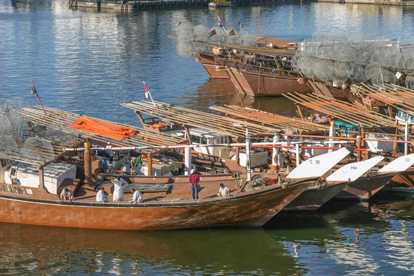 SHARJAH, BAE - 30 Aralık 2004: Geleneksel bir balıkçı teknesinin mürettebatı, gargur ya da balık tuzaklarıyla dolu, Birleşik Arap Emirlikleri 'ndeki Sharjah Köprüsü yakınlarında balık tutuyor..