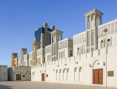 Arkaplanda daha modern Arap tarzı bir bina bulunan, Birleşik Arap Emirlikleri 'ndeki Sharjah kentinin restore edilmiş Miras Bölgesi.