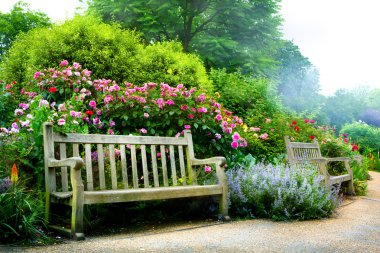 Art bench and flowers in the morning in an English park clipart