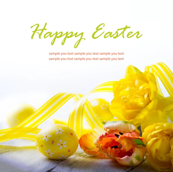 Kunst paaseieren en gele voorjaar bloem op witte achtergrond — Stockfoto
