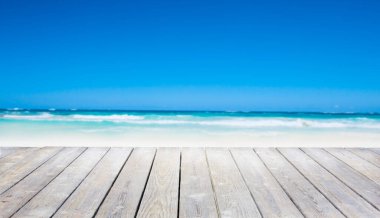 Ön planda beyaz ahşap panel olan deniz kumu sahili arka planı