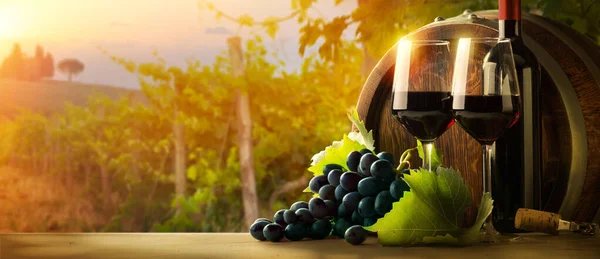 赤ワインボトル ワイングラス 木製の樽 美しいイタリアトスカーナのブドウ畑の背景 — ストック写真