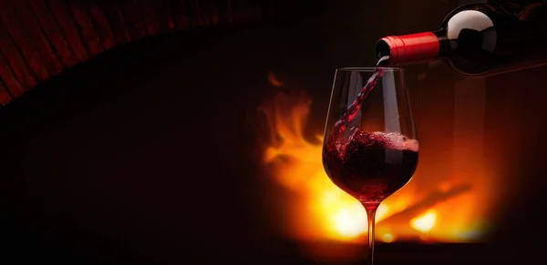 Versare Vino Rosso Bicchiere Notte Vicino Camino Fiamme Accogliente Sfondo — Foto Stock