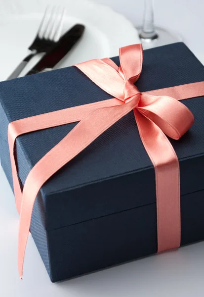 Geschenkbox in einer dekorativen roten Schleife — Stockfoto