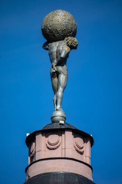 Vilnius, Litvanya - 11 Mayıs 2021: Cennetin mahzenini koruyan Atlas 'ın restore edilmiş şekli Merchants Club' ın silindirik tareti, tarihi iş merkezi. 