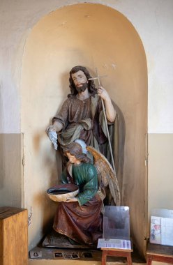 Suderve, Litvanya - 2 Nisan 2017: Vaftizci Yahya 'nın heykeli ve Suderve, Litvanya' daki Kutsal Üçlü Kilisesi 'nin duvarında bir kutsal su kabı (stoup).