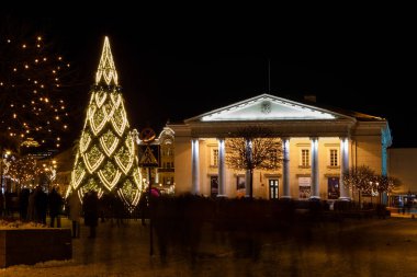 Vilnius, Litvanya - 26 Aralık 2021: Eski Vilnius kasabasındaki Belediye Binası Meydanı 'nda bulunan süslü Noel ağacının gece manzarası.