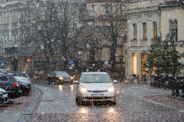 Vilnius, Litvanya - 30 Mart 2022 - Vilnius eski kasabasındaki Pilies Caddesi, yoğun bir kar yağışı sırasında. Şehirde soğuk karlı hava. 
