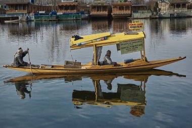 Dal Gölü, Srinagar, Kaşmir, Hindistan - 18 Şubat 2012: Fotoğraf dükkanı ve fotoğraf servisi ile geleneksel Kaşmir sarı teknesi. 