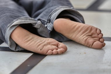 Çocuk bacakları mermer zeminde.                