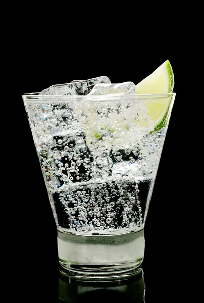 Água espumante com cubos de gelo e pedaço de limão — Fotografia de Stock