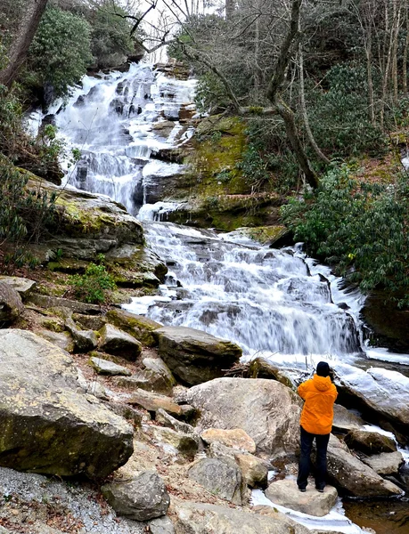 Une personne qui regarde une cascade gelée — Photo