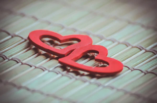 Two red hearts on bamboo napkin — Stock Photo, Image