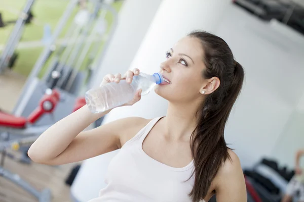 Flicka dricksvatten i gymmet — Stockfoto
