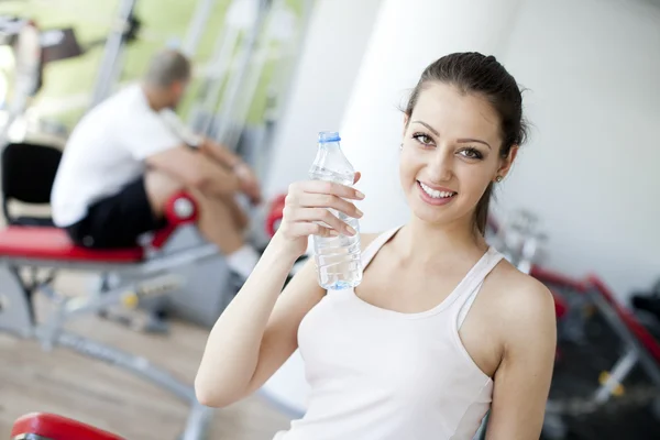 Chica bebiendo agua en el gimnasio — Foto de Stock