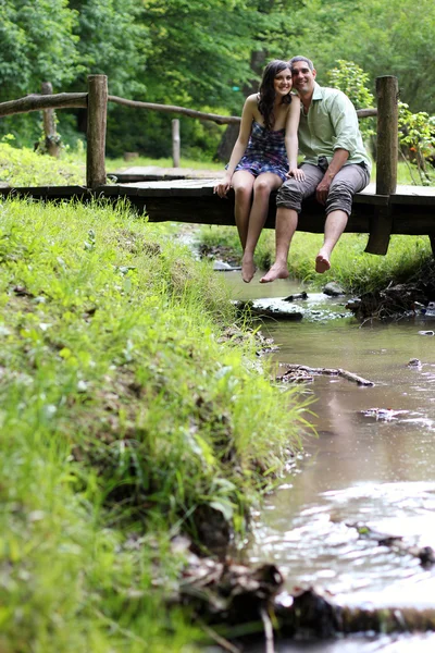 Casal amoroso na ponte de madeira — Fotografia de Stock