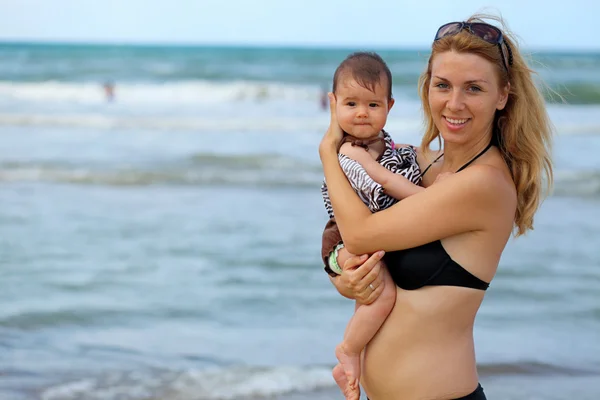 Moeder en baby op het strand — Stockfoto