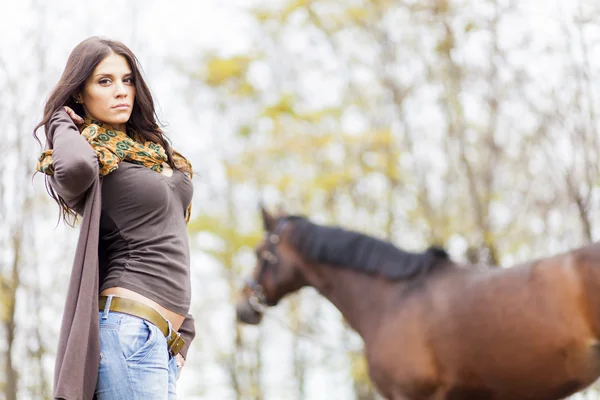 Mujer joven con un caballo — Foto de Stock