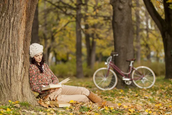 Jeune femme lisant dans la forêt d'automne — Photo