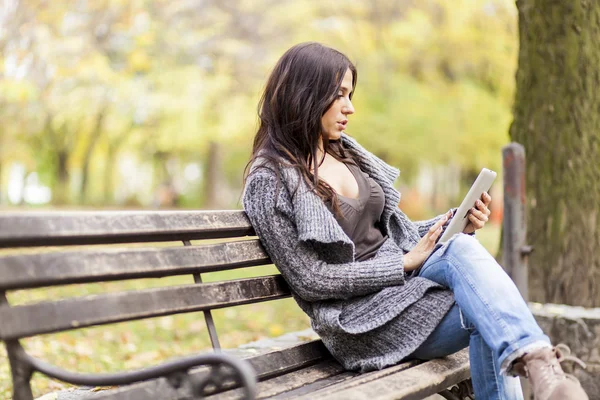 Jonge vrouw met tablet op de Bank — Stockfoto