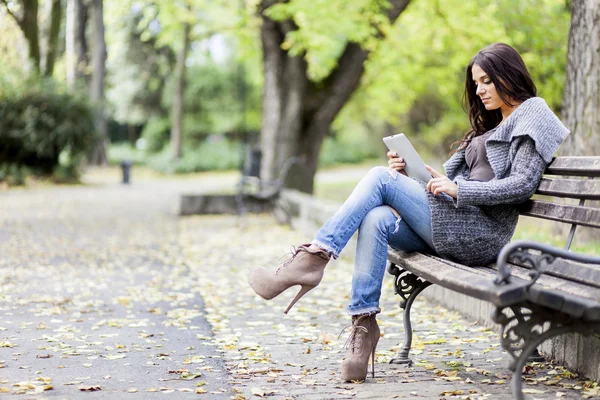 Jeune femme avec tablette sur le banc — Photo