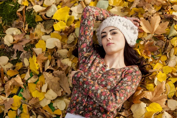 Young woman laying in the autumn leaves — Stock Photo, Image