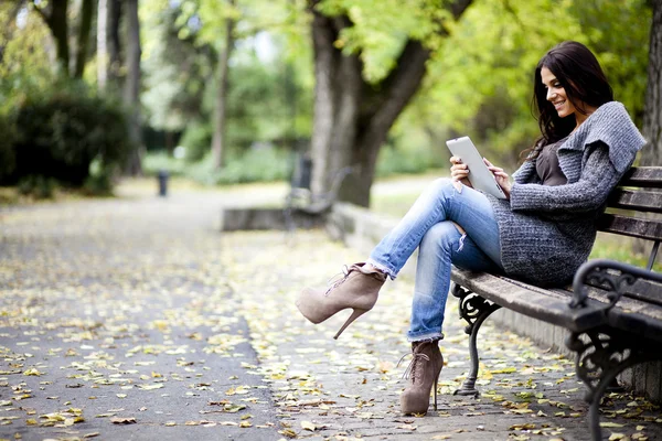 Jonge vrouw met tablet op de Bank — Stockfoto