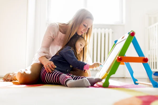 Mother and daughter drawing in the room — Stock Photo, Image