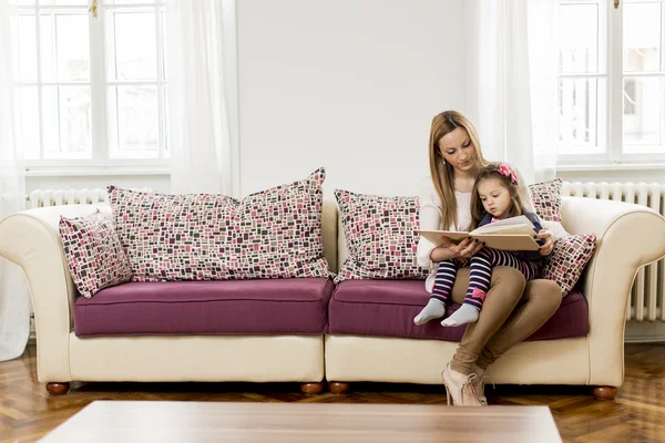 Mother and daughter reading in the room — Stock Photo, Image
