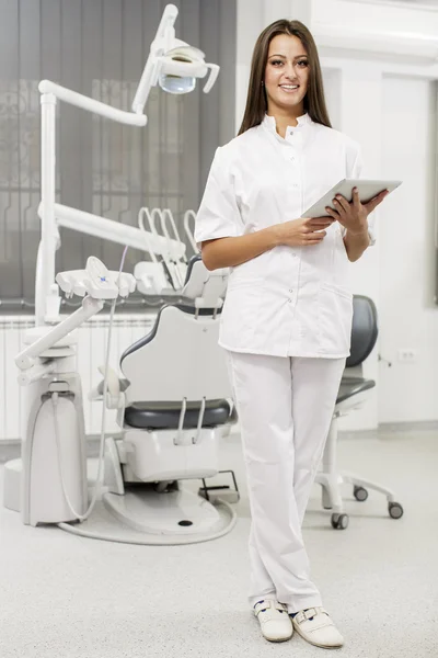 Junge Zahnärztin mit Tablet — Stockfoto