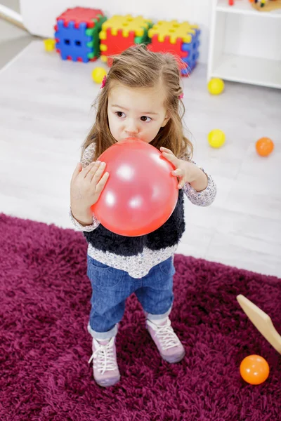 Menina com balão no quarto — Fotografia de Stock