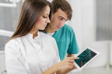 Young dentists with tablet clipart
