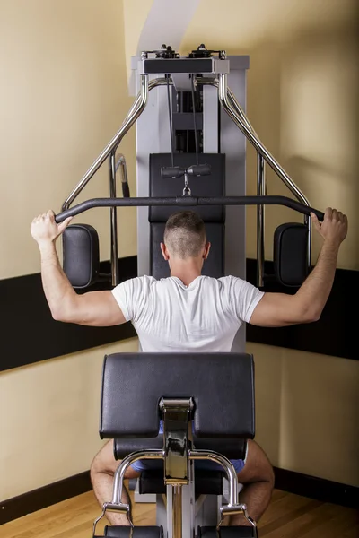 Jeune homme s'entraînant dans la salle de gym — Photo