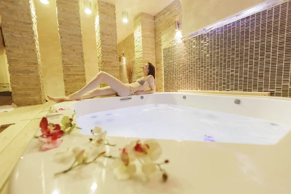 Mujer joven relajándose en la bañera de hidromasaje — Foto de Stock