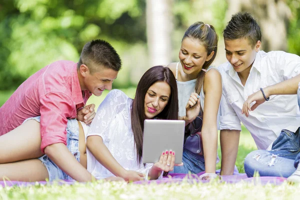 Adolescentes en el parque con tableta —  Fotos de Stock