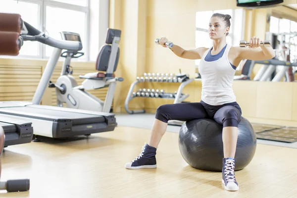 Spor salonunda çalışan genç bir kadın. — Stok fotoğraf