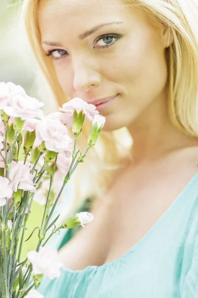 Young blond woman with flowers — Stock Photo, Image