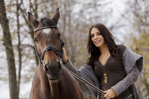 Mujer joven con un caballo — Foto de Stock