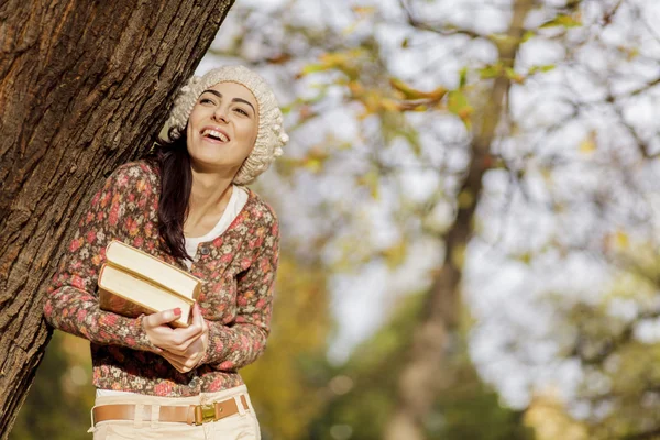 Jonge vrouw met boeken op de herfst bos — Stockfoto