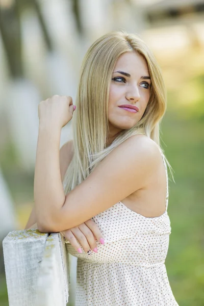 Młoda blond kobieta przez płot — Zdjęcie stockowe