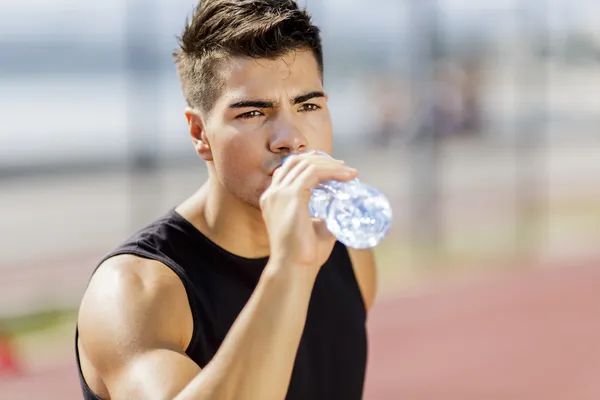 Genç adam su içiyor. — Stok fotoğraf