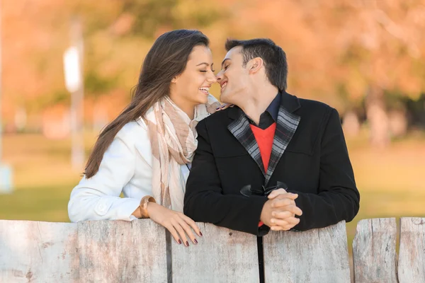 Pareja joven junto a la valla — Foto de Stock