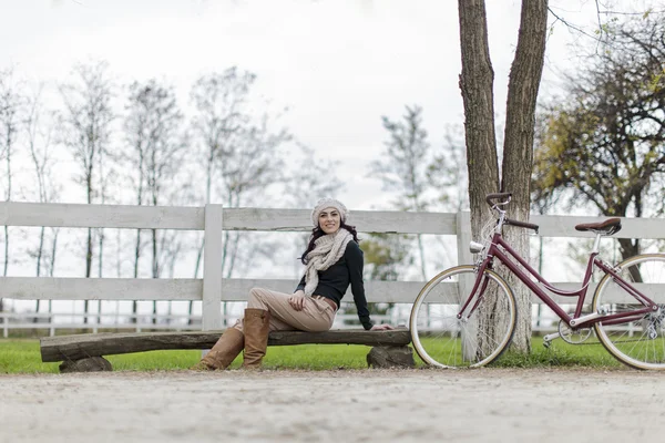 Giovane donna con una bicicletta — Foto Stock