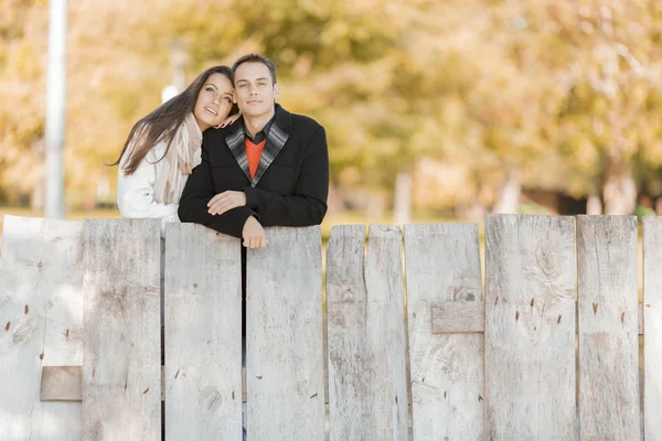 柵の中で若いカップル — ストック写真