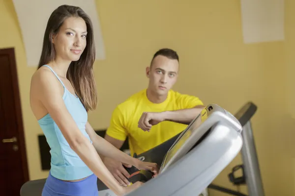 Ung man och kvinna i gymmet — Stockfoto