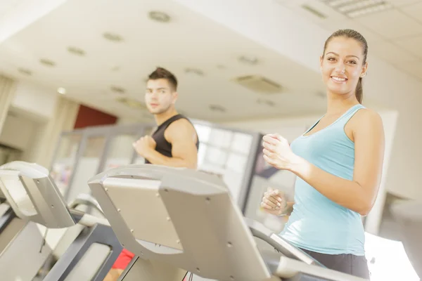 Young man and woman in the gym — Stock Photo, Image